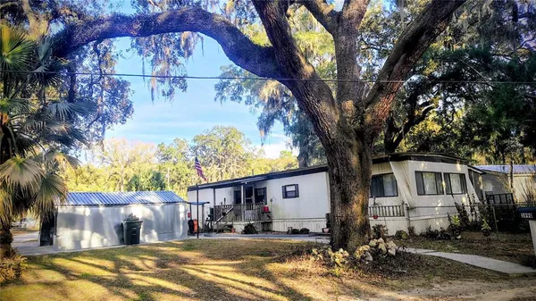 a front view of a house with a large tree