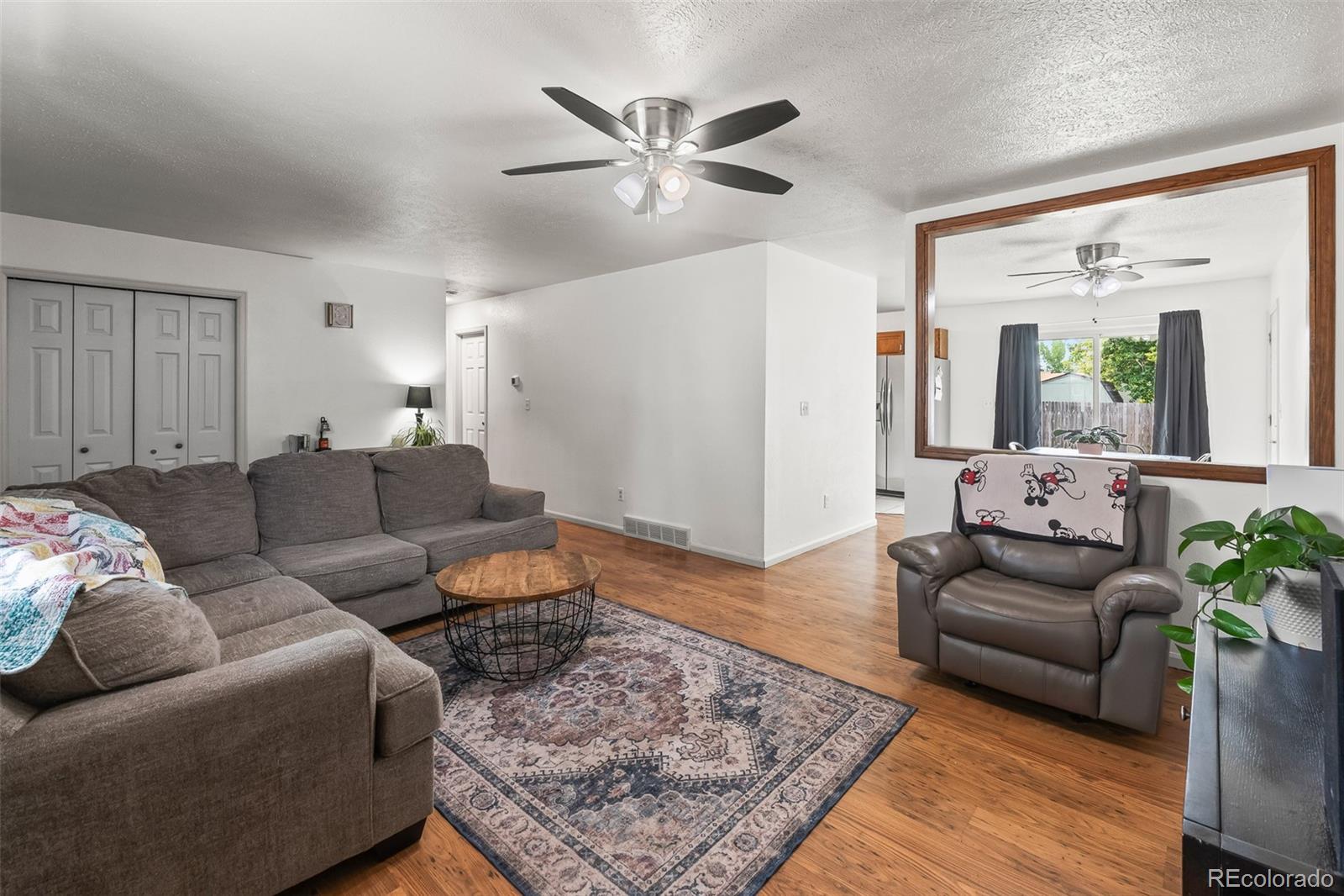 908 Trapper Drive Fort Lupton, CO 80621 - Photo 11 of 41 a living room with furniture rug and wooden floor