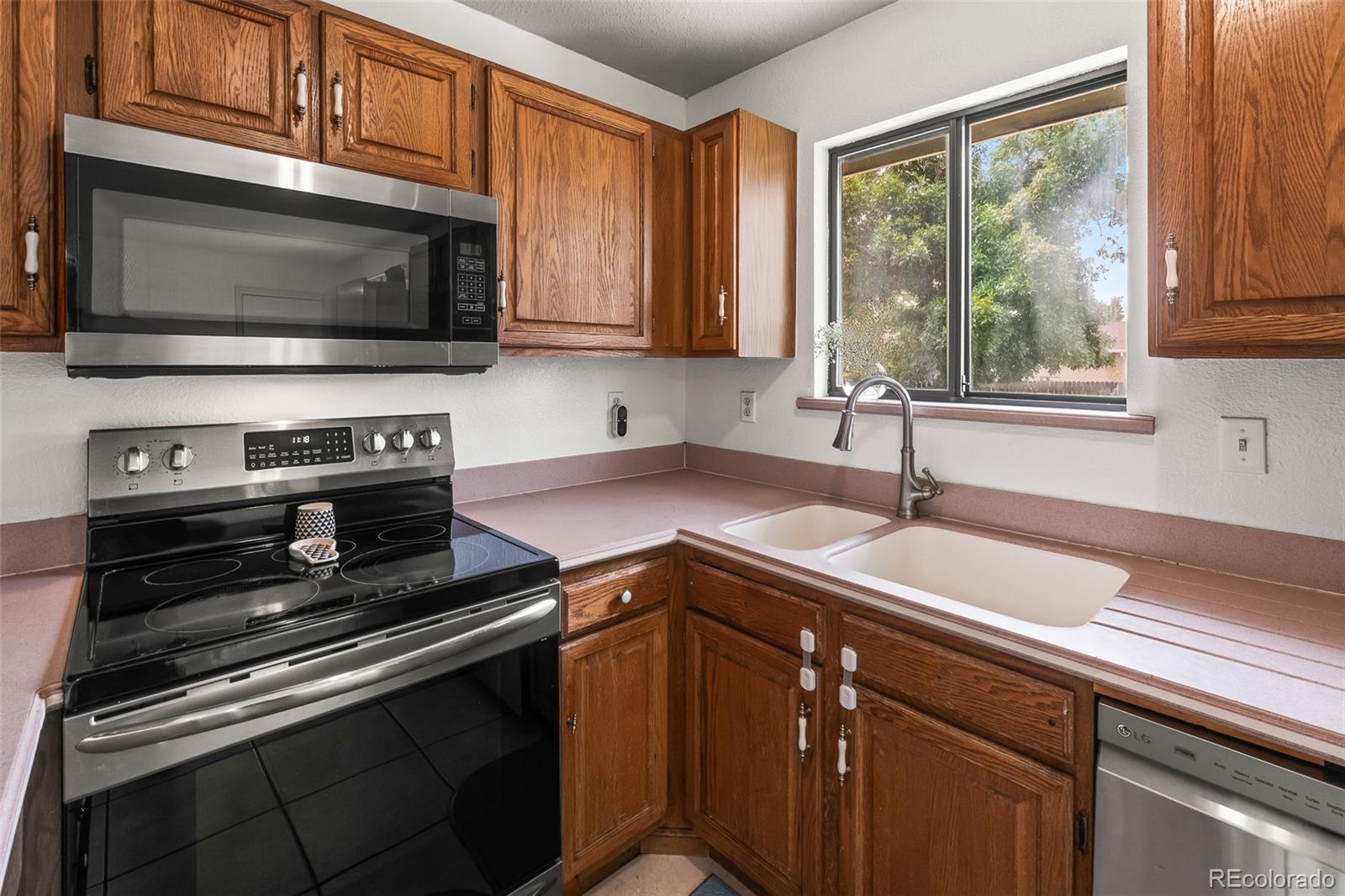 908 Trapper Drive Fort Lupton, CO 80621 - Photo 15 of 41 a kitchen with a sink stove and microwave