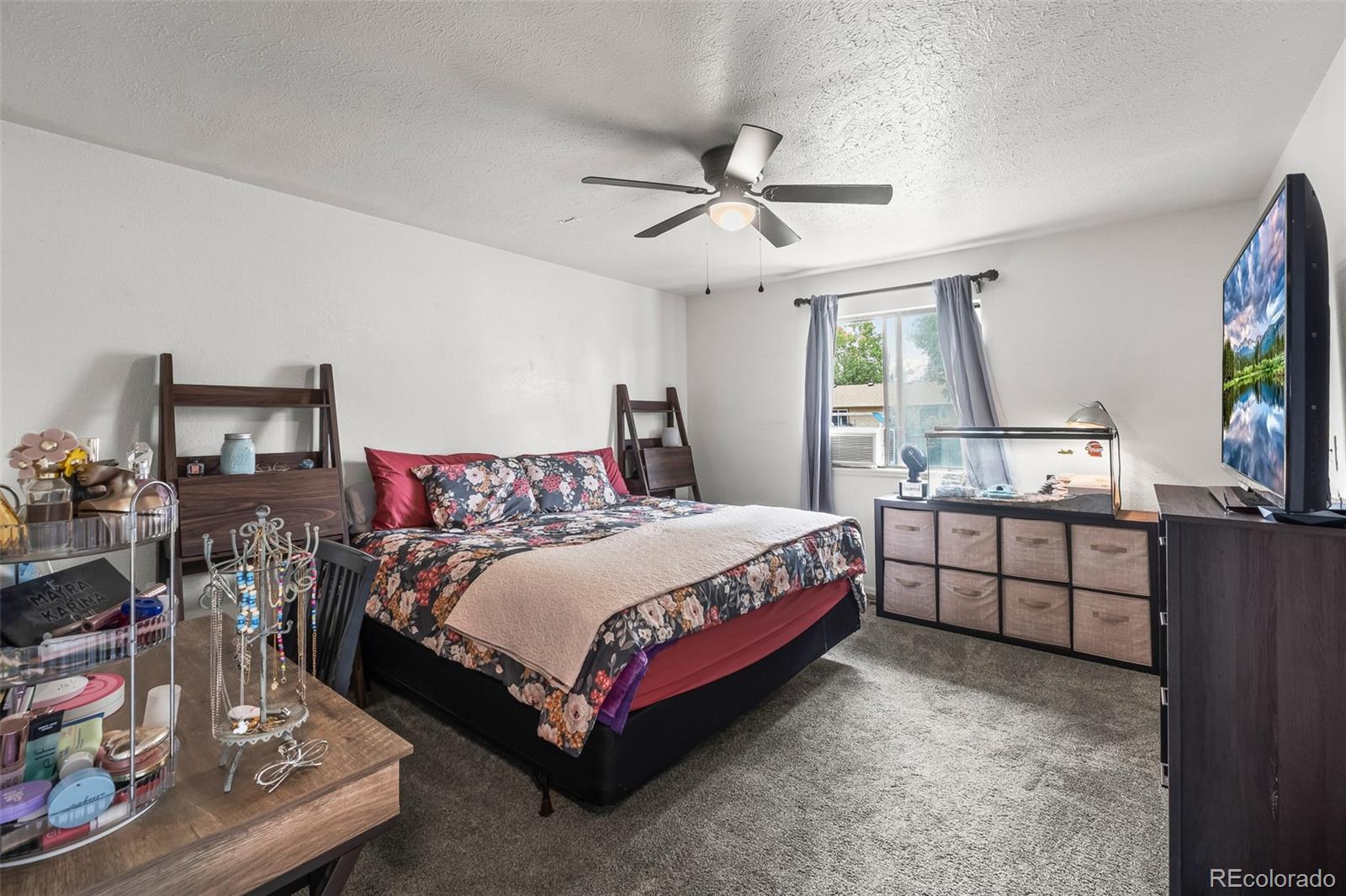 908 Trapper Drive Fort Lupton, CO 80621 - Photo 18 of 41 a spacious bedroom with a bed and a flat screen tv