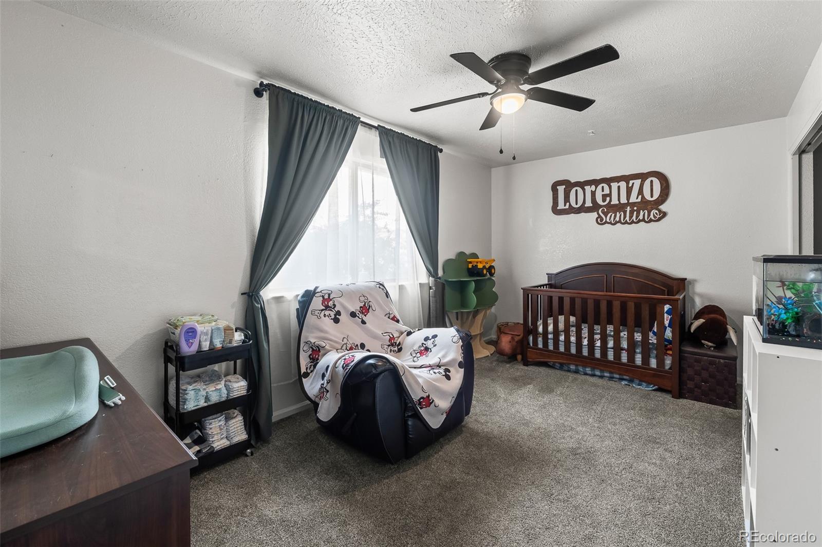 908 Trapper Drive Fort Lupton, CO 80621 - Photo 22 of 41 a bedroom with a bed and a chandelier