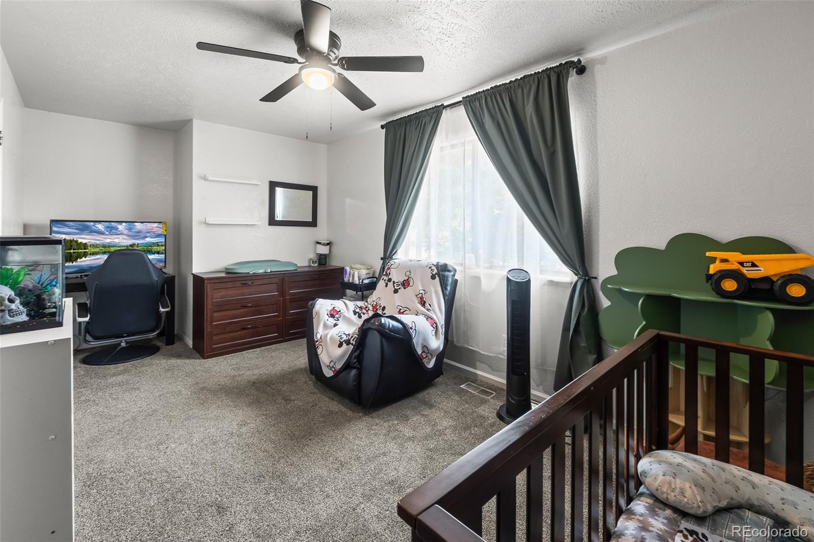 908 Trapper Drive Fort Lupton, CO 80621 - Photo 23 of 41 a bedroom with furniture and a window