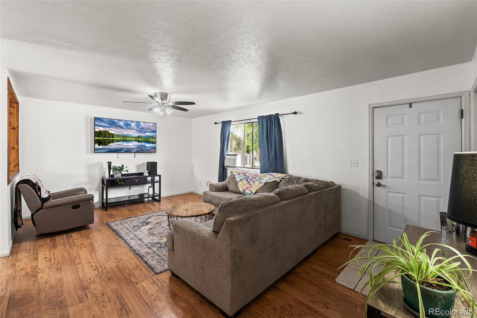 908 Trapper Drive Fort Lupton, CO 80621 - Photo 9 of 41 a living room with furniture and a flat screen tv