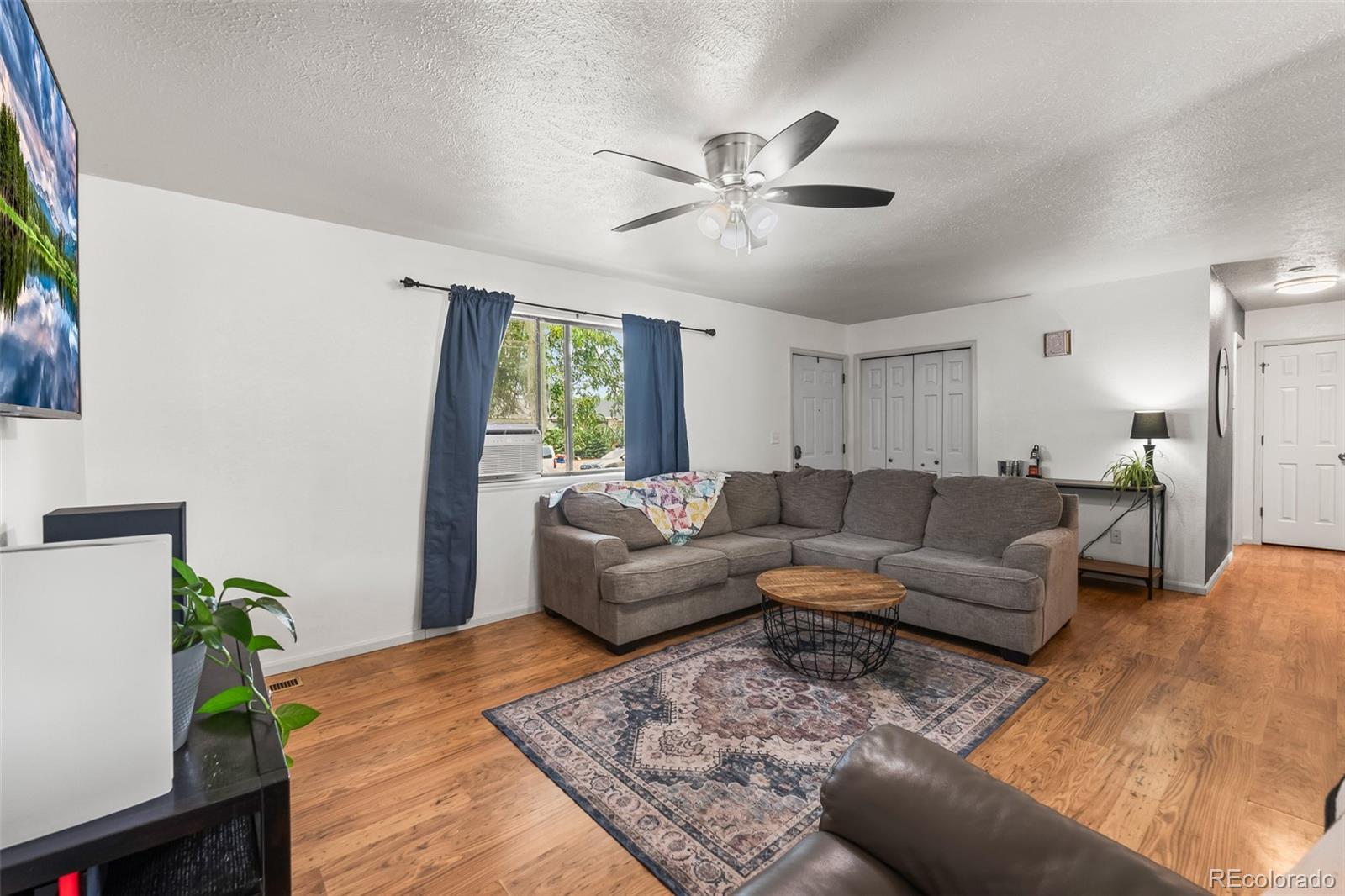 908 Trapper Drive Fort Lupton, CO 80621 - Photo 10 of 41 a living room with furniture and a large window