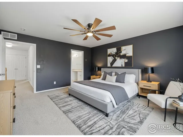 a spacious bedroom with a bed and a chandelier