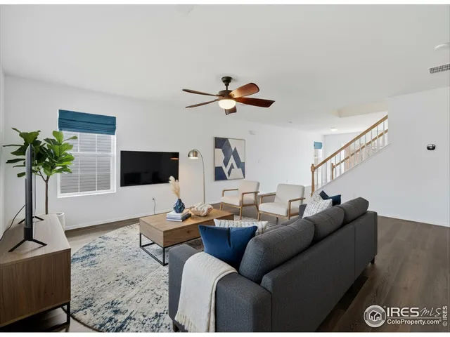 a living room with furniture a flat screen tv and a potted plant