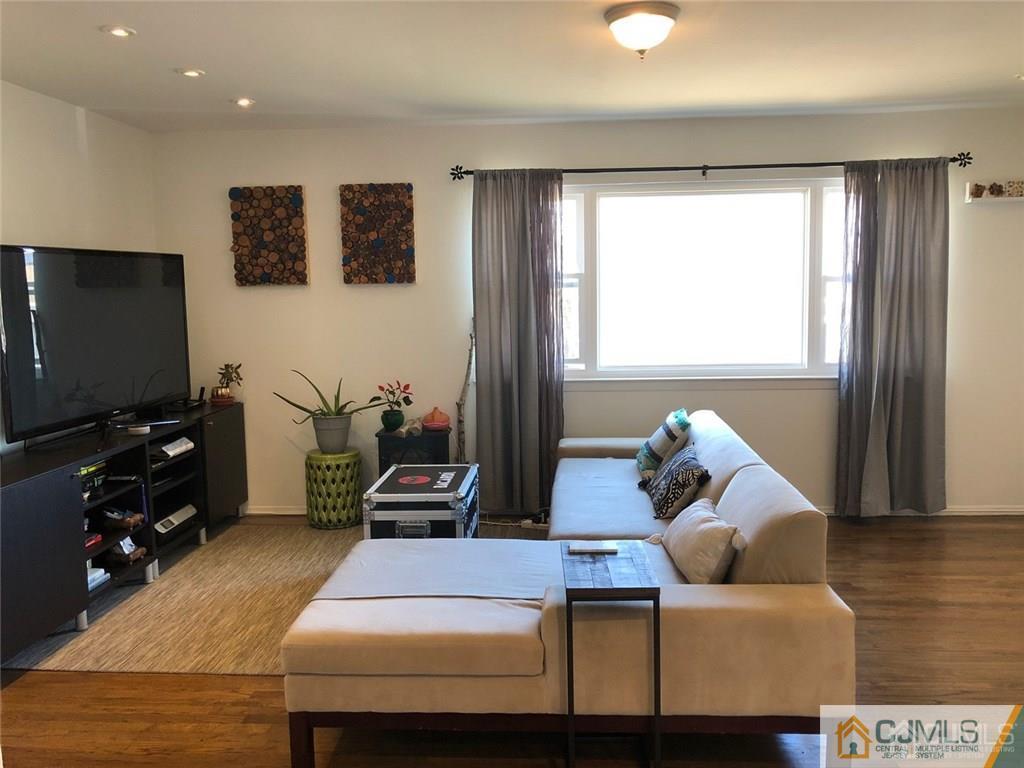 57 Judson Street, Unit 1B Edison, NJ 08837 - Photo 11 of 21 a living room with furniture and a flat screen tv