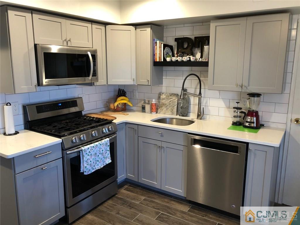 57 Judson Street, Unit 1B Edison, NJ 08837 - Photo 8 of 21 a kitchen with stainless steel appliances granite countertop a stove a sink and a microwave