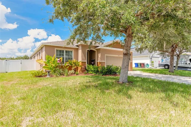 a front view of house with yard and trees around
