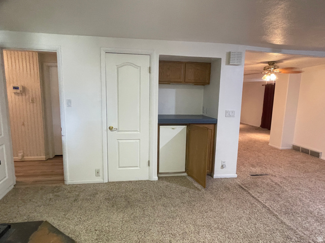 438 East Main Street Elsinore, UT 84724 - Photo 24 of 43 Built-in wet bar featuring upper and lower cabinetry with a solid surface countertop and fridge.