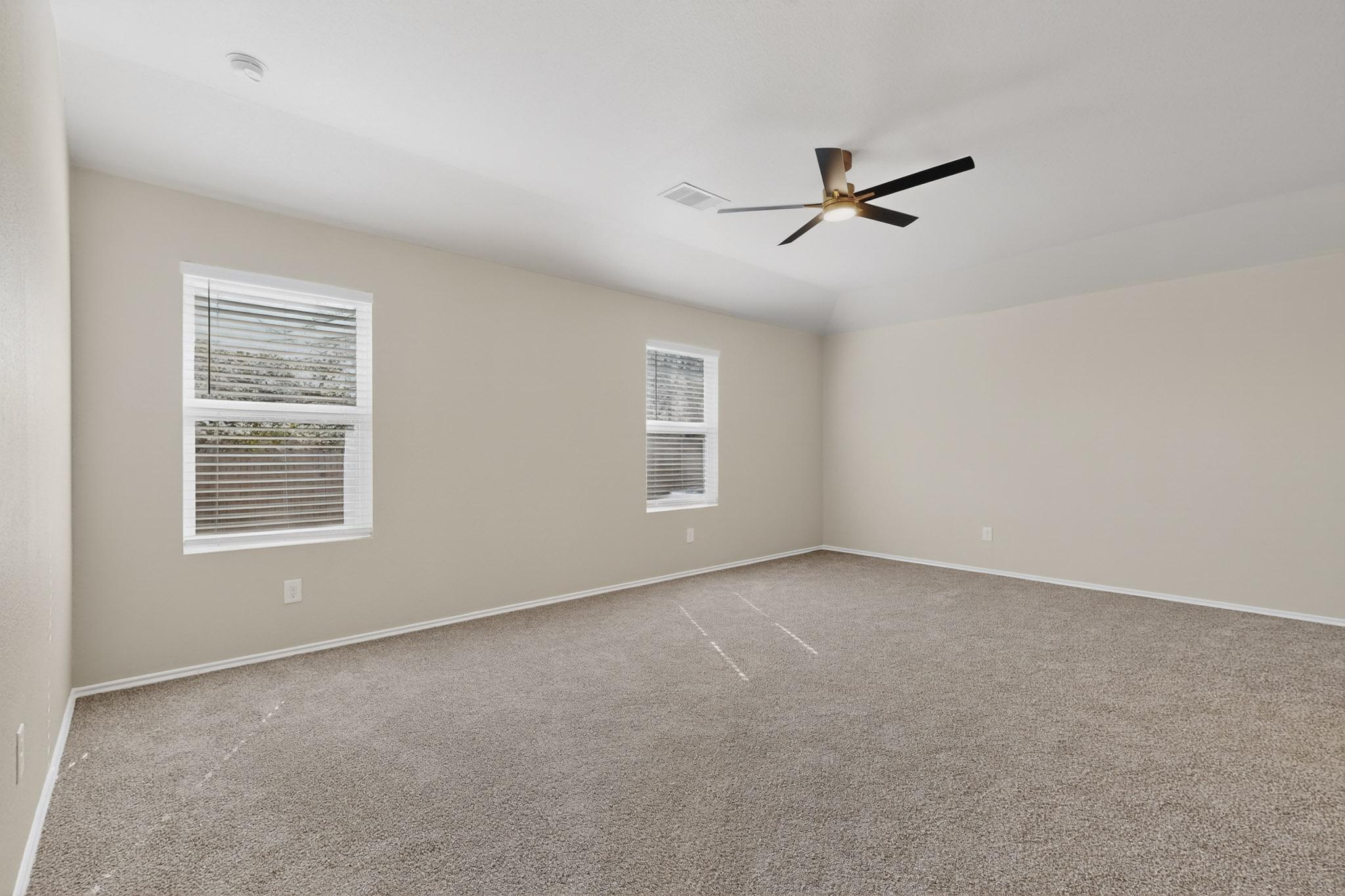 218 Sickle Loop Kyle, TX 78640 - Photo 11 of 34 Spare room with light colored carpet, plenty of natural light, and a ceiling fan
