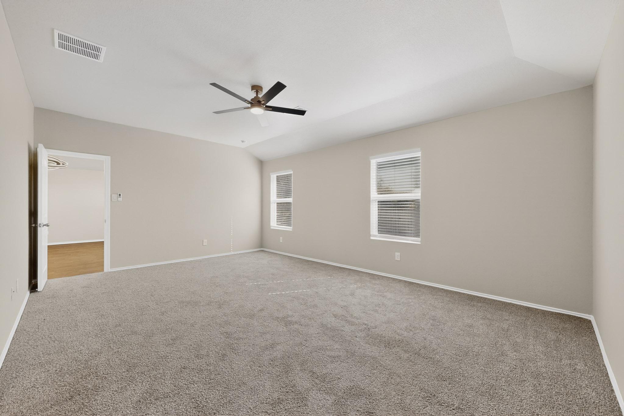 218 Sickle Loop Kyle, TX 78640 - Photo 12 of 34 Carpeted spare room with ceiling fan and vaulted ceiling