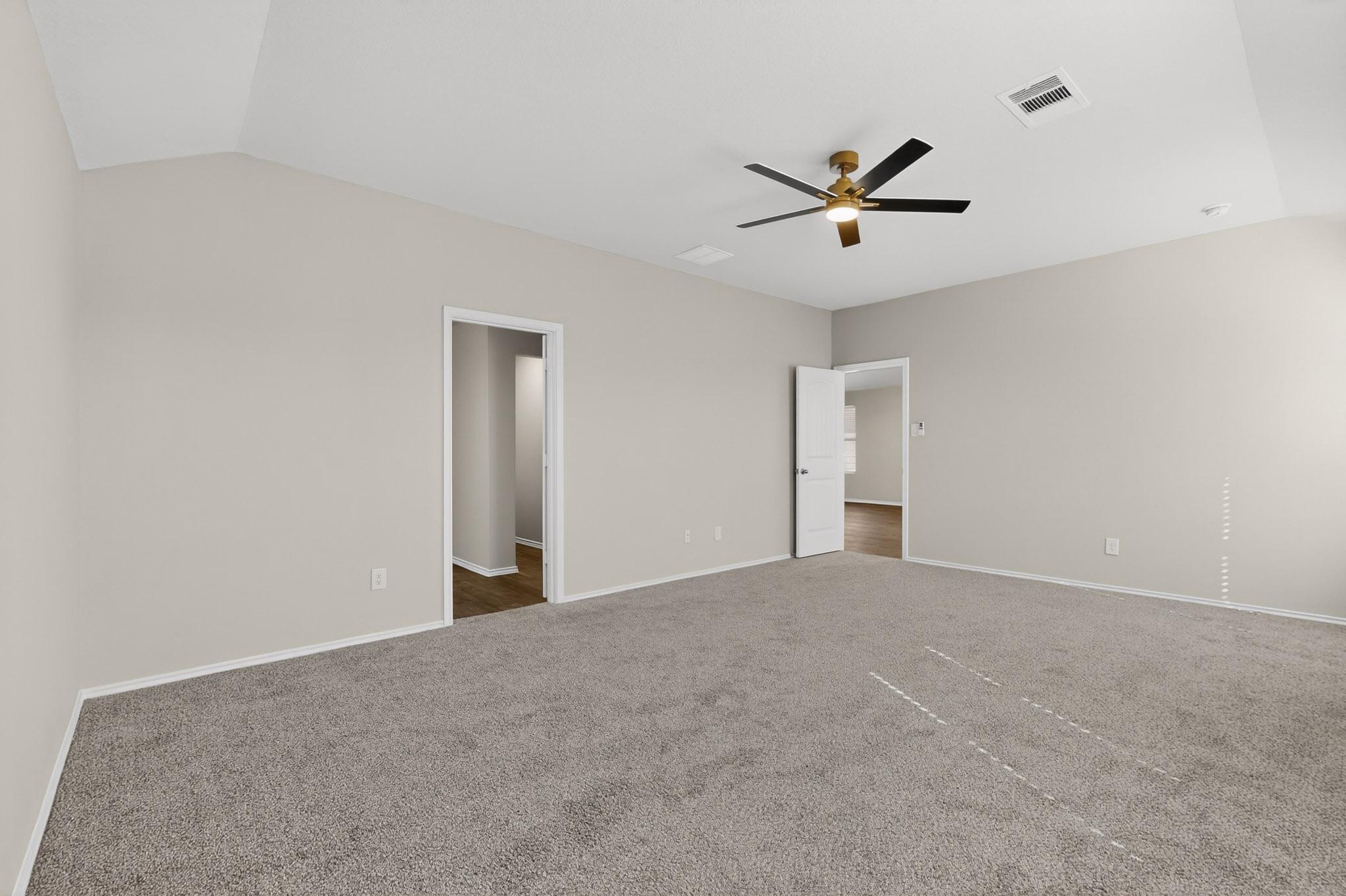 218 Sickle Loop Kyle, TX 78640 - Photo 13 of 34 Unfurnished bedroom with carpet, vaulted ceiling, and ceiling fan