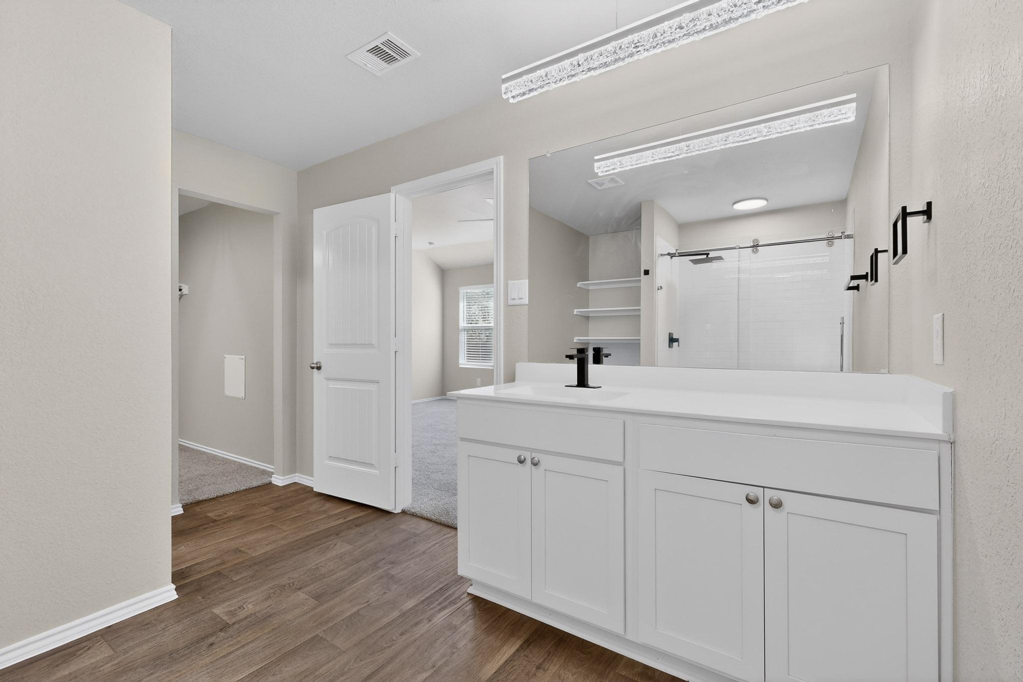 218 Sickle Loop Kyle, TX 78640 - Photo 14 of 34 Bathroom featuring a shower stall, vanity, and dark wood-style flooring