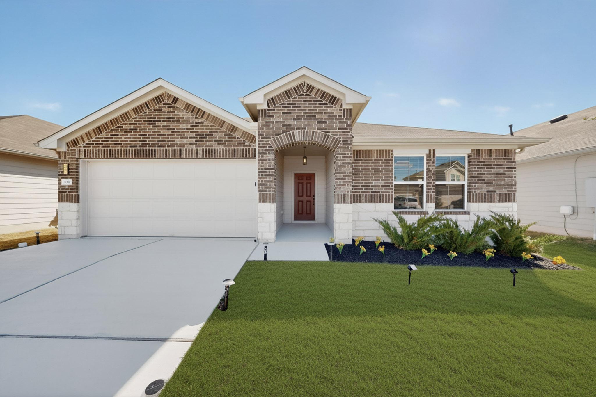 218 Sickle Loop Kyle, TX 78640 - Photo 2 of 34 View of front of home with brick siding, an attached garage, driveway, and a front yard