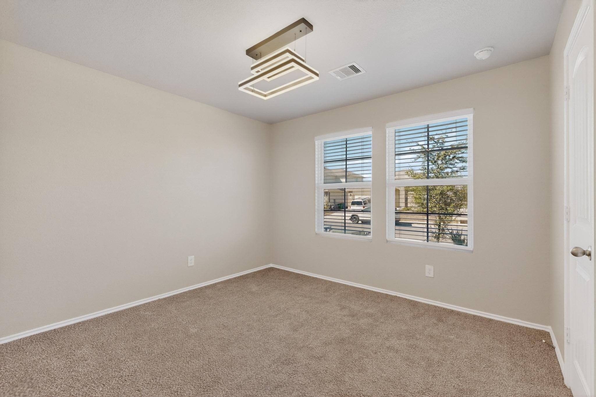 218 Sickle Loop Kyle, TX 78640 - Photo 24 of 34 Unfurnished room featuring baseboards and light carpet
