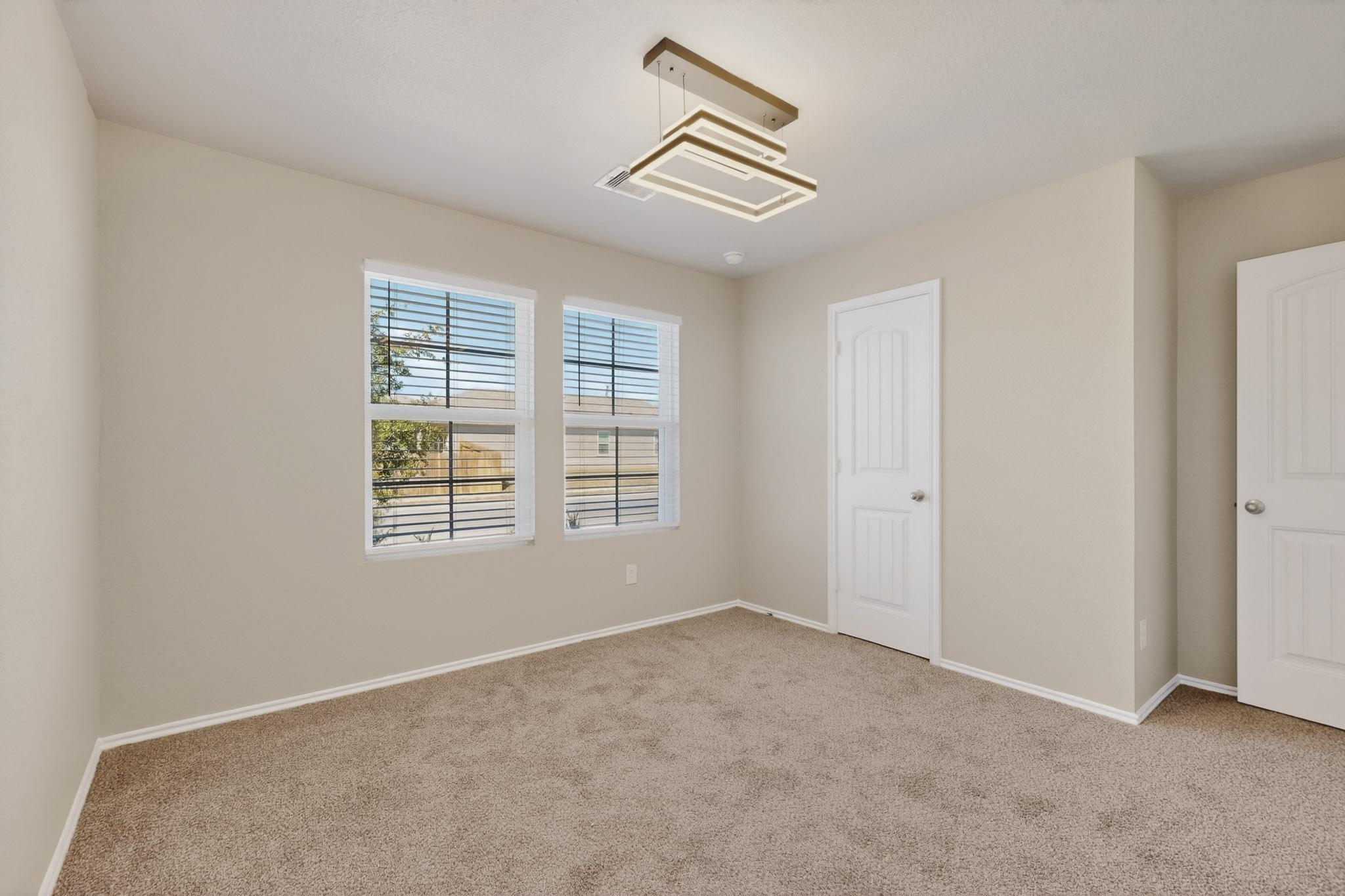 218 Sickle Loop Kyle, TX 78640 - Photo 25 of 34 Unfurnished bedroom featuring light colored carpet and baseboards