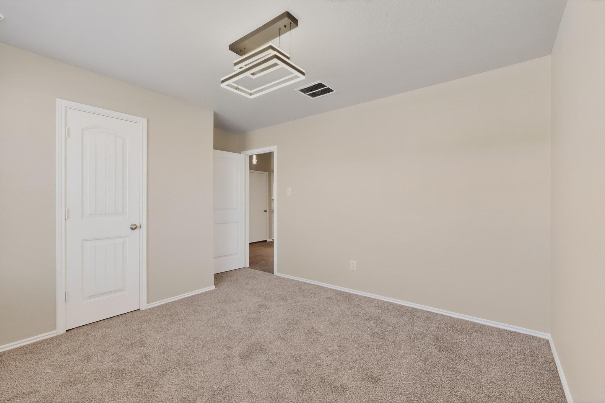 218 Sickle Loop Kyle, TX 78640 - Photo 26 of 34 Unfurnished bedroom featuring light carpet and baseboards