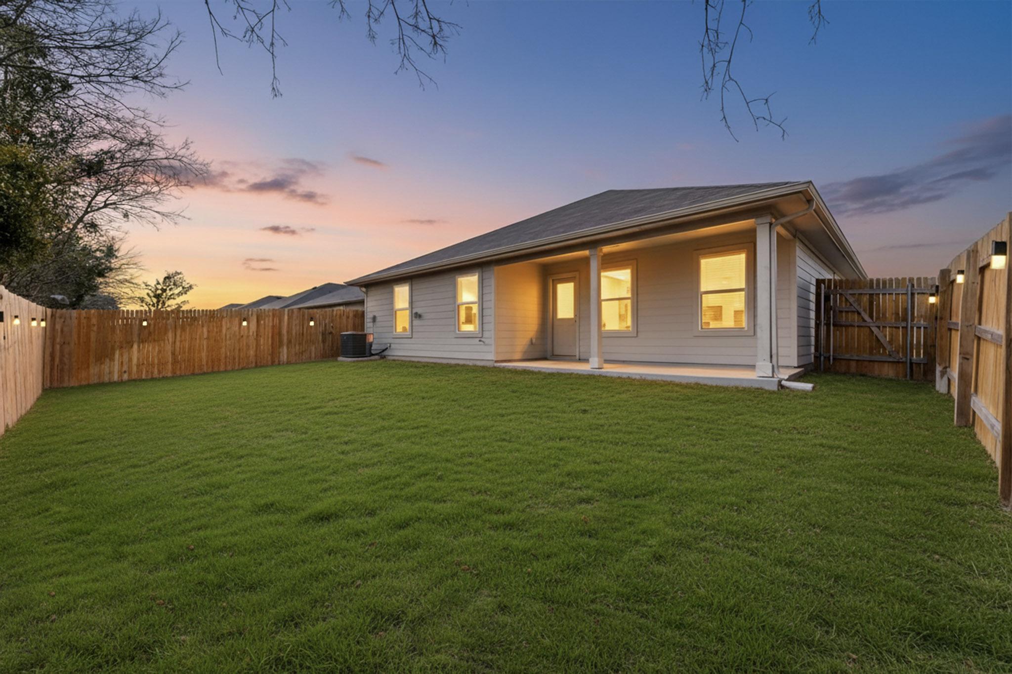 218 Sickle Loop Kyle, TX 78640 - Photo 30 of 34 Back of house at dusk featuring a patio area and a fenced backyard