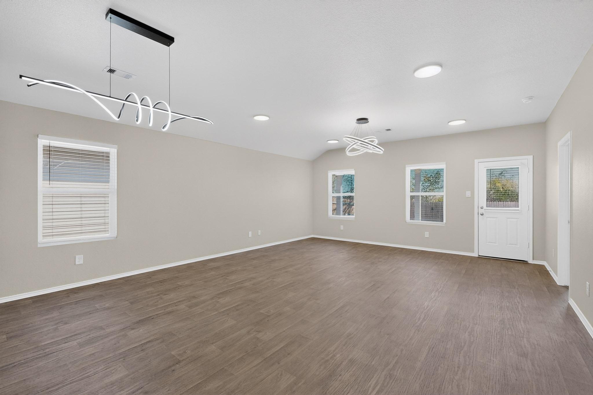 218 Sickle Loop Kyle, TX 78640 - Photo 4 of 34 Unfurnished room with dark wood finished floors and a chandelier