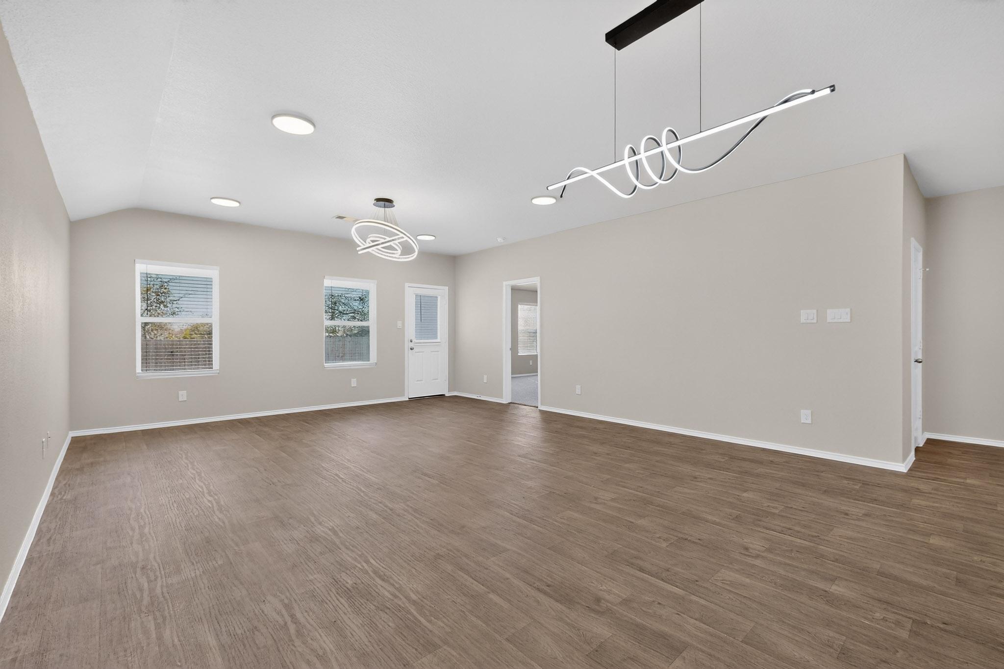 218 Sickle Loop Kyle, TX 78640 - Photo 5 of 34 Empty room featuring a chandelier, dark wood-style floors, and recessed lighting