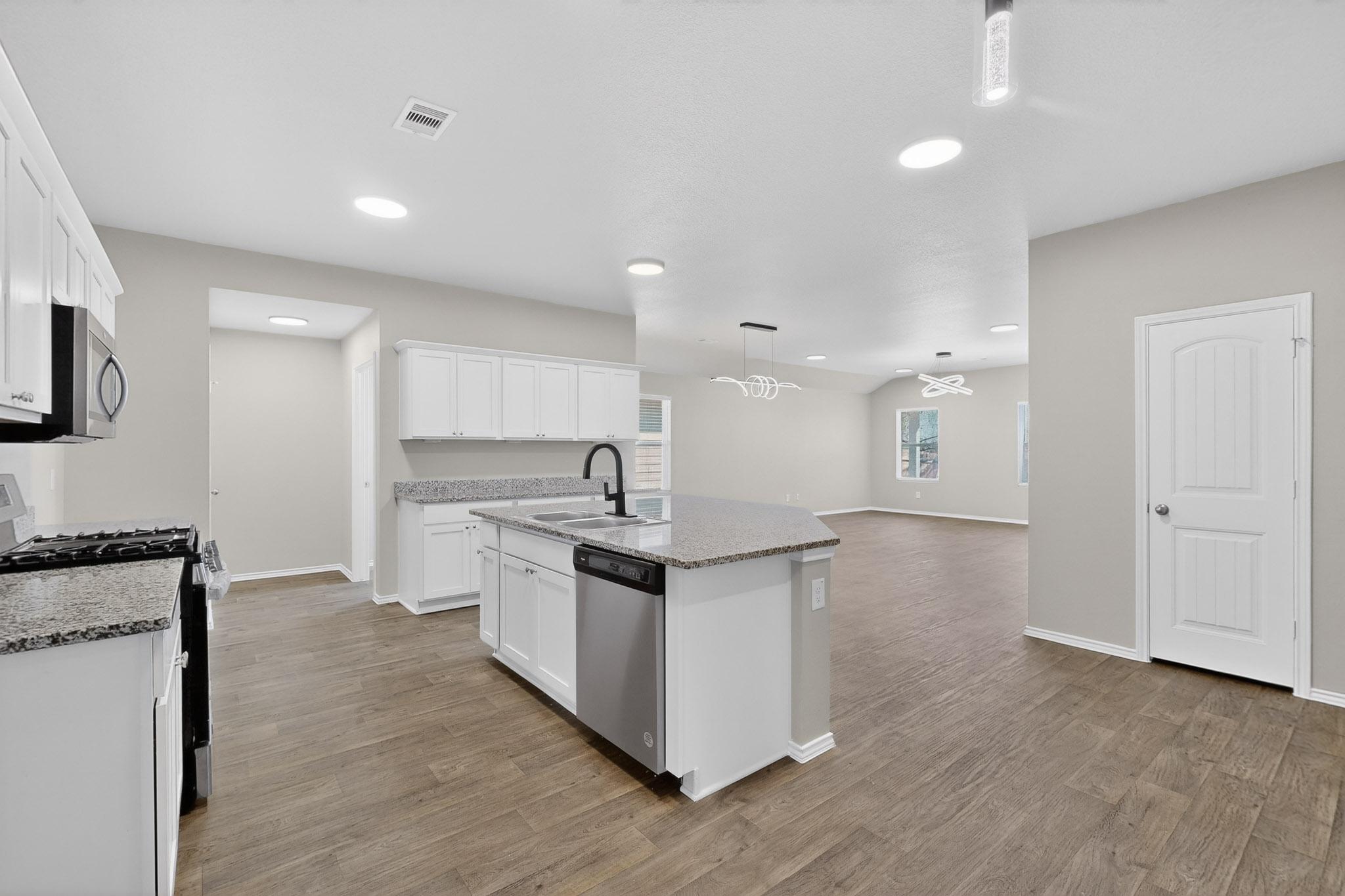218 Sickle Loop Kyle, TX 78640 - Photo 33 of 34 Kitchen with appliances with stainless steel finishes, decorative light fixtures, a kitchen island with sink, white cabinetry, and open floor plan