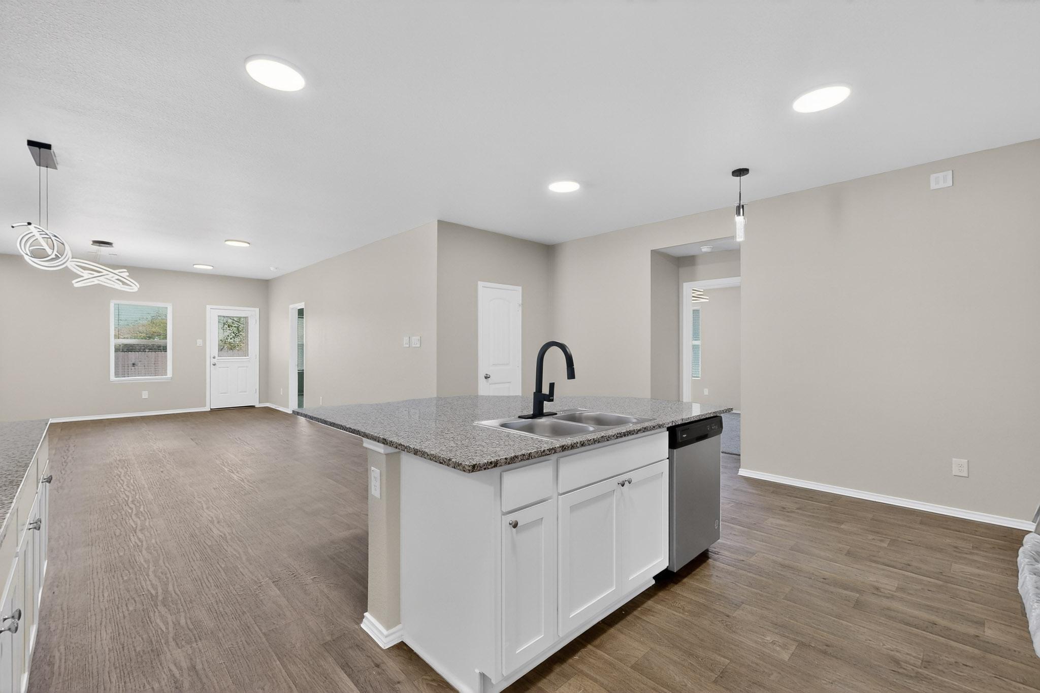 218 Sickle Loop Kyle, TX 78640 - Photo 34 of 34 Kitchen with pendant lighting, open floor plan, white cabinetry, dark wood-type flooring, and recessed lighting