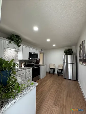 a living room with a bed and a potted plant