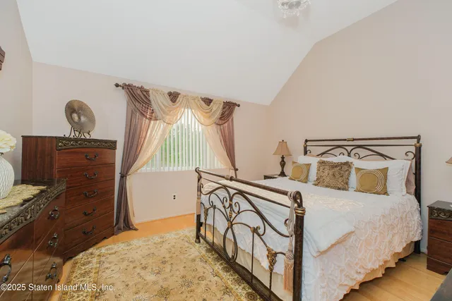 a bedroom with bed and wooden floor