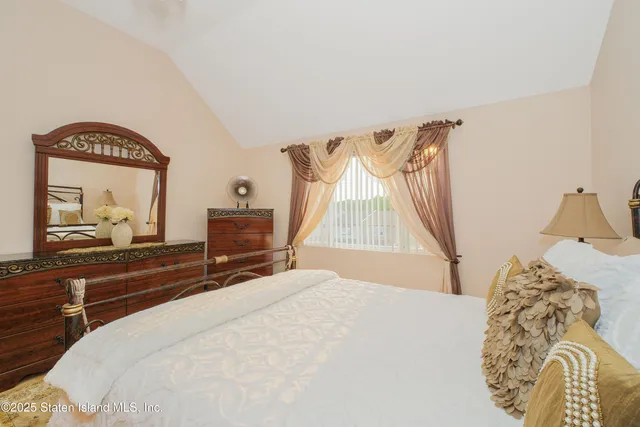 a bedroom with a bed and a mirror on dresser