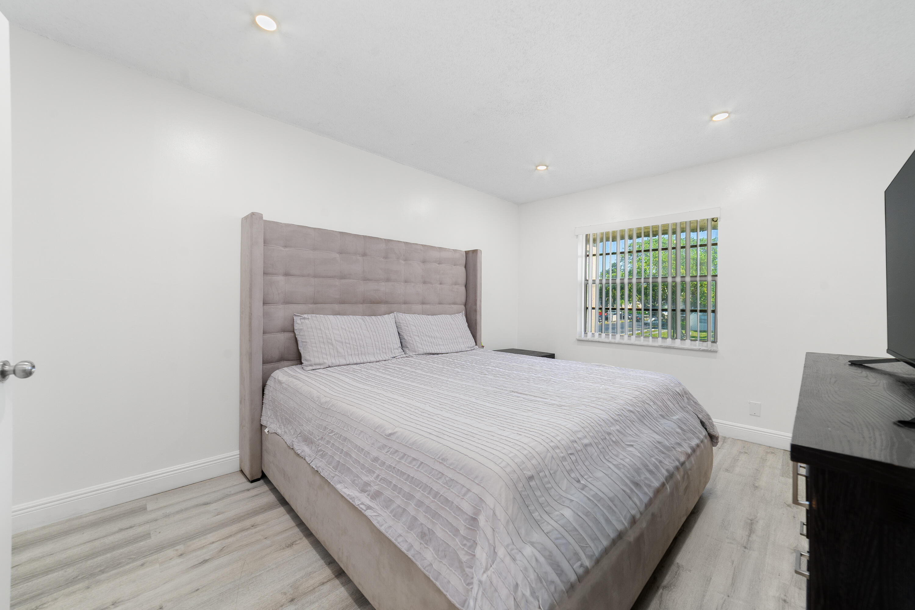2710 Riverside Drive, Unit 201A Coral Springs, FL 33065 - Photo 11 of 23 a large bed sitting in a bedroom next to a window