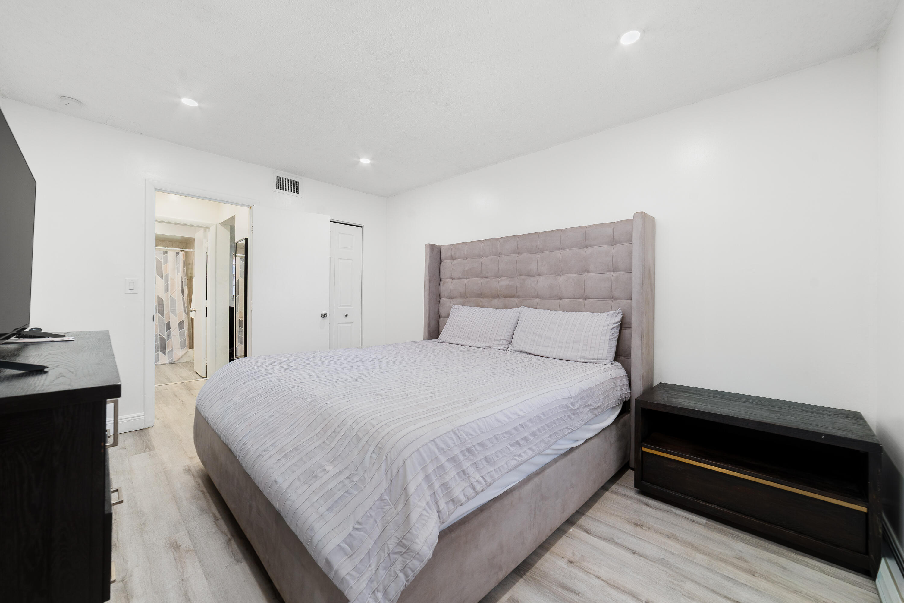 2710 Riverside Drive, Unit 201A Coral Springs, FL 33065 - Photo 12 of 23 a spacious bedroom with a bed and a dresser