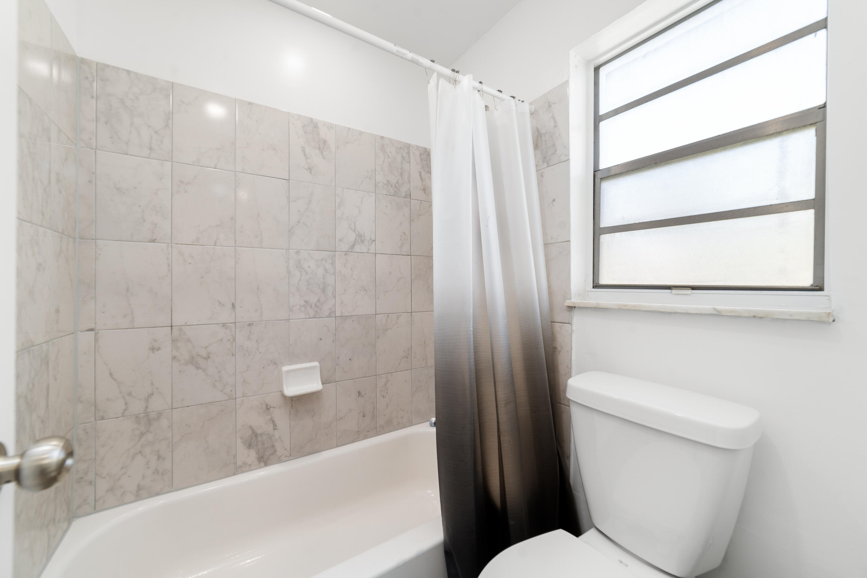 2710 Riverside Drive, Unit 201A Coral Springs, FL 33065 - Photo 16 of 23 a bathroom with a toilet and a bathtub