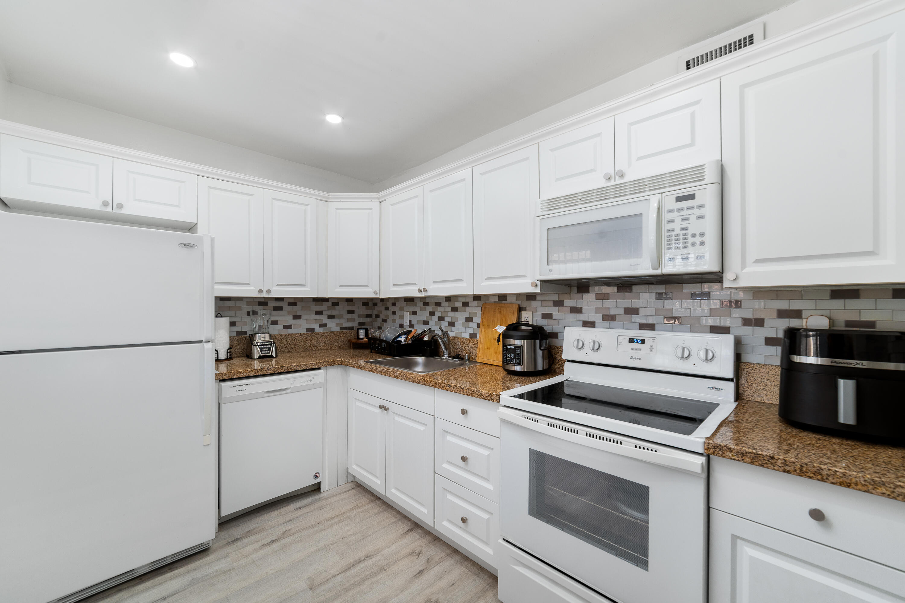 2710 Riverside Drive, Unit 201A Coral Springs, FL 33065 - Photo 7 of 23 a kitchen with granite countertop white cabinets and white appliances