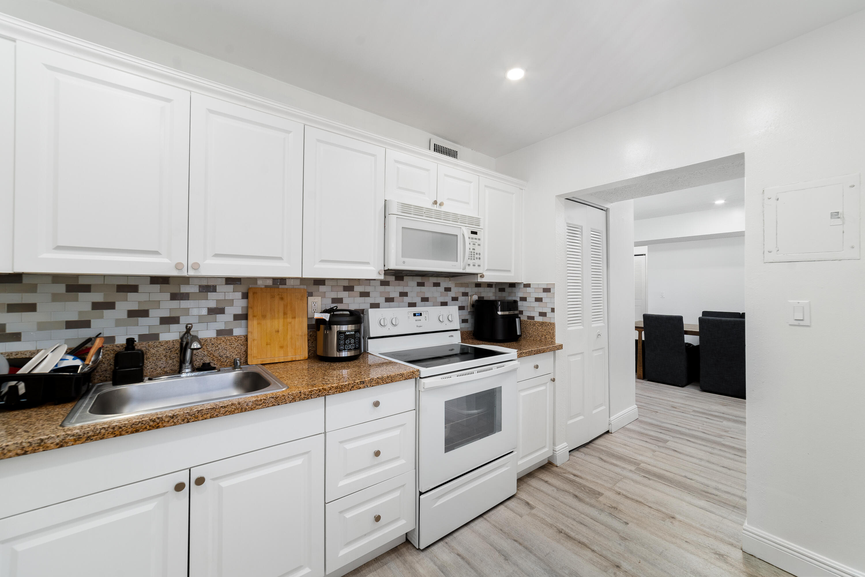 2710 Riverside Drive, Unit 201A Coral Springs, FL 33065 - Photo 9 of 23 a kitchen with granite countertop white cabinets and white appliances