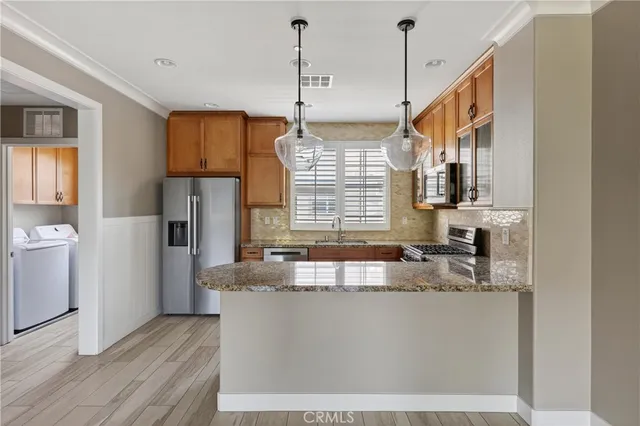 a kitchen with kitchen island a counter top space wooden floor and a large window
