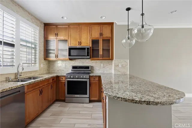 a kitchen with stainless steel appliances granite countertop a sink stove and refrigerator