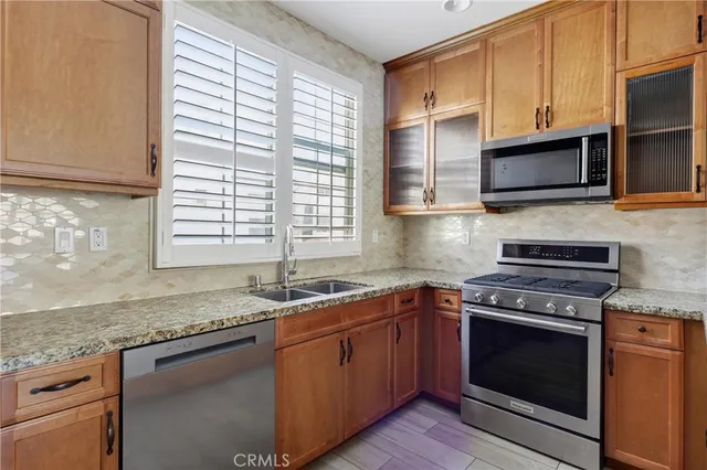 a kitchen with granite countertop a sink stainless steel appliances and cabinets