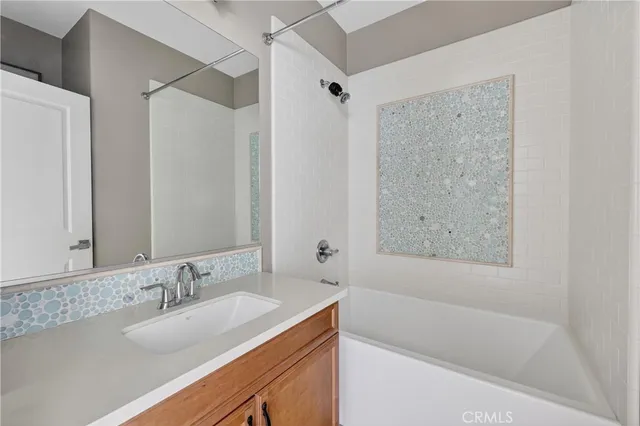a bathroom with a granite countertop sink mirror toilet and bathtub
