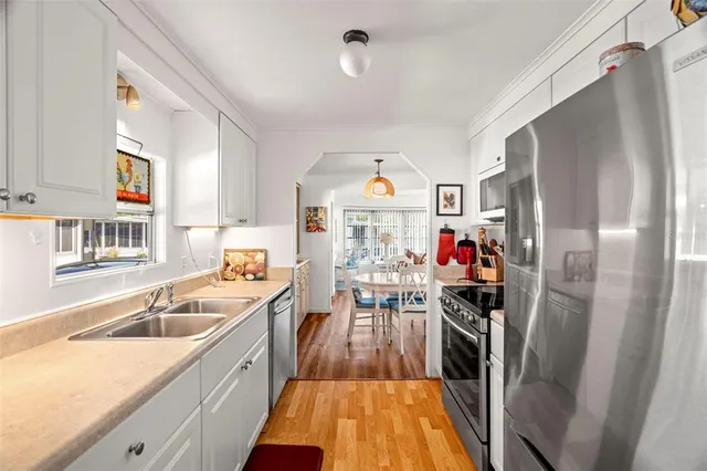 a view of a kitchen with a sink dishwasher stove and refrigerator