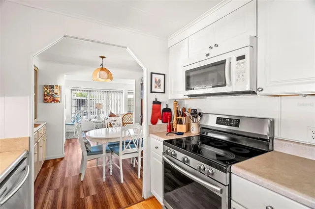 a view of kitchen with microwave stove dining table and chairs