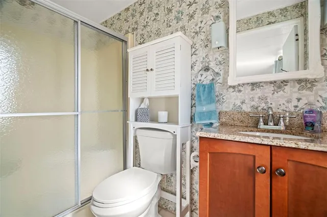 a bathroom with a granite countertop sink toilet and shower