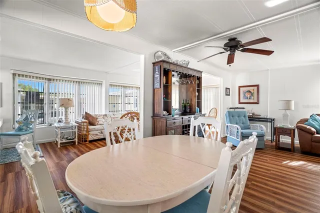 a dining room with furniture a chandelier and wooden floor