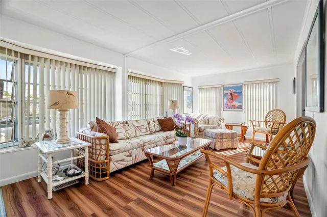 a living room with furniture a wooden floor and a large window