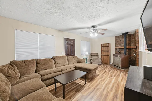 a living room with furniture ceiling fan and a wooden floor