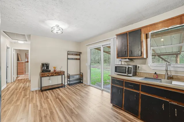 a kitchen with kitchen island granite countertop a sink appliances cabinets and furniture