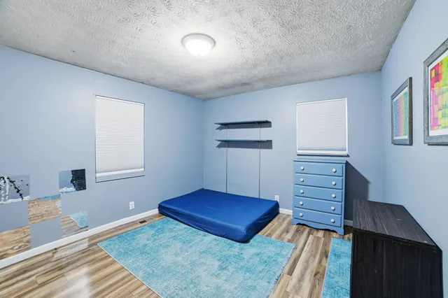 a view of a bedroom with furniture and wooden floor