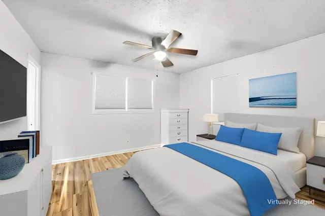 a bedroom with a large bed and a flat tv screen on dresser