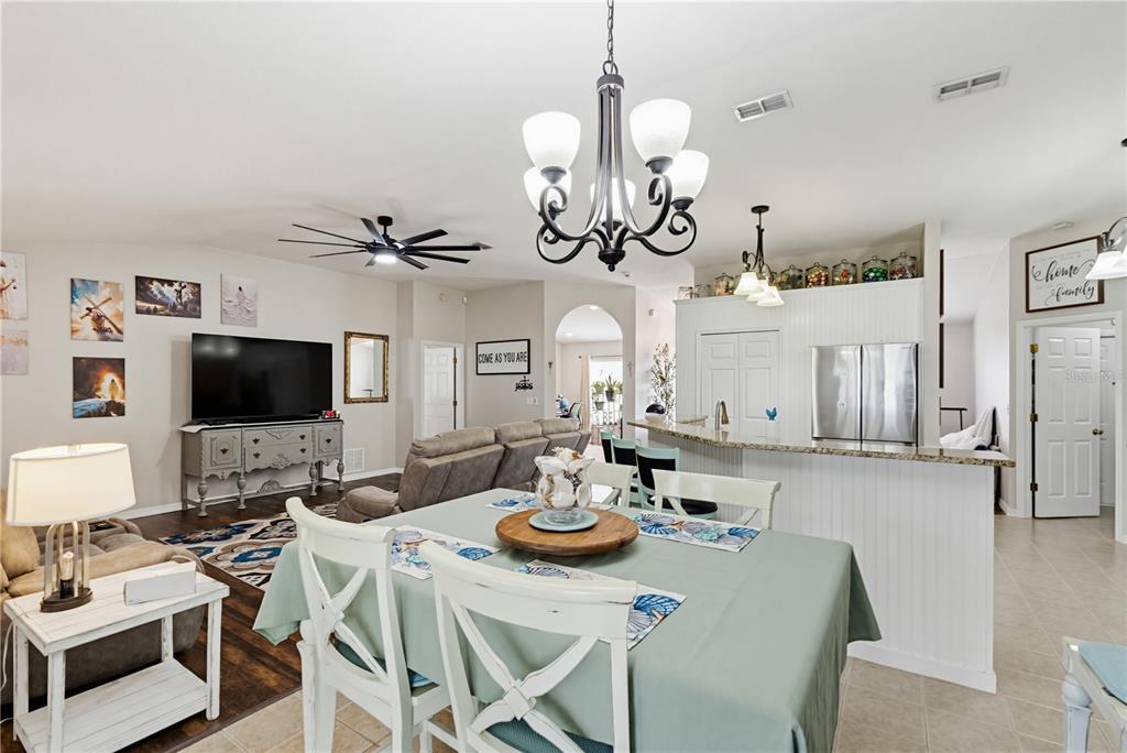 3497 Chadwick Avenue Spring Hill, FL 34609 - Photo 11 of 47 a view of a dining room with furniture a chandelier and wooden floor