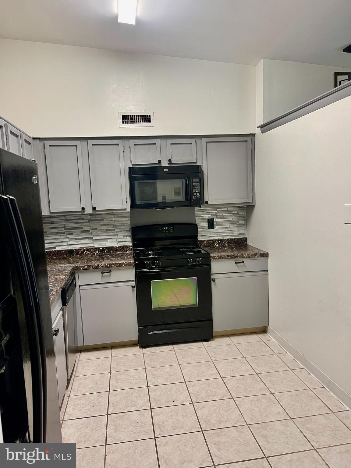60201 Delaire Landing Road, Unit 201 Philadelphia, PA 19114 - Photo 13 of 49 a kitchen with granite countertop a stove a sink and a refrigerator